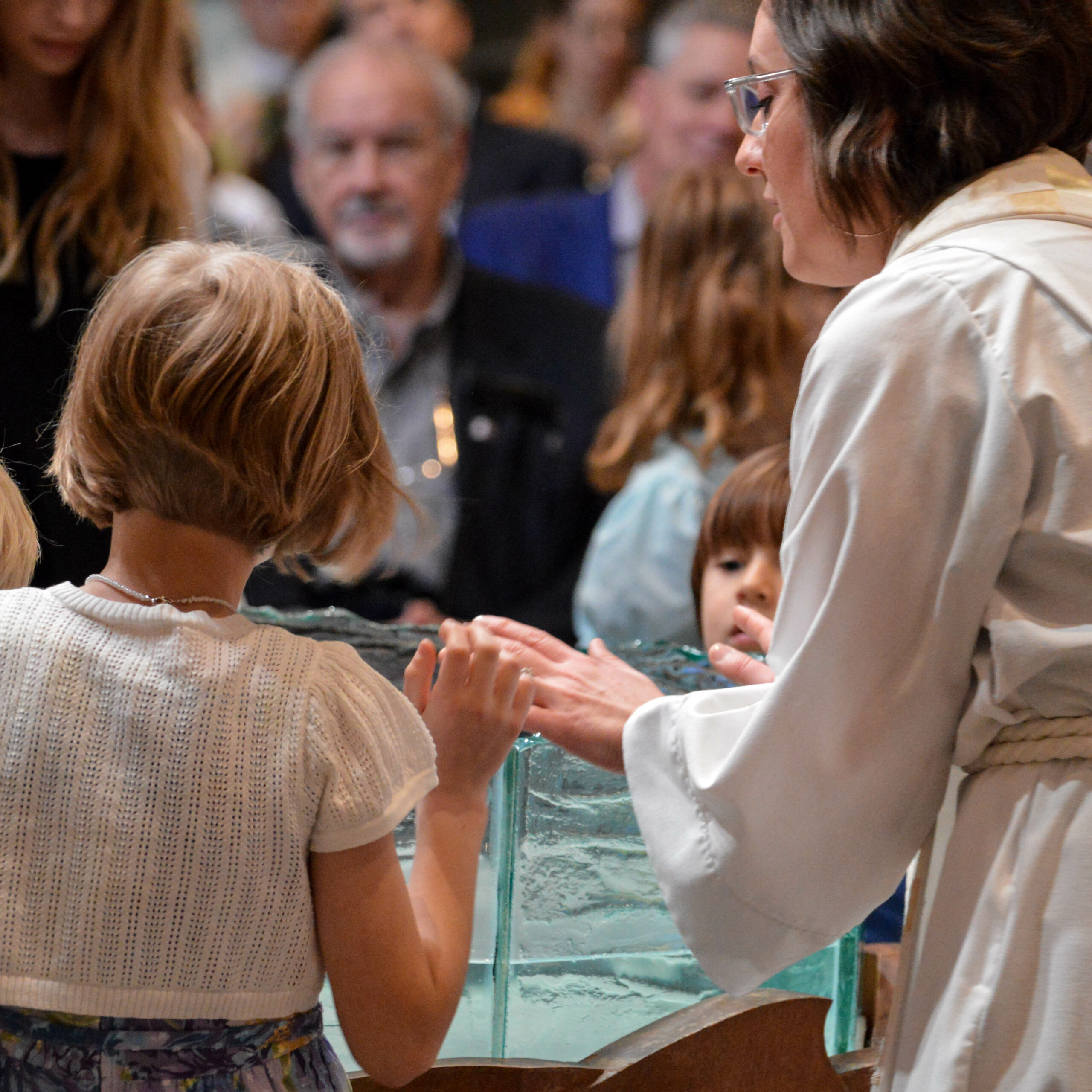children and pastor at the baptismal font