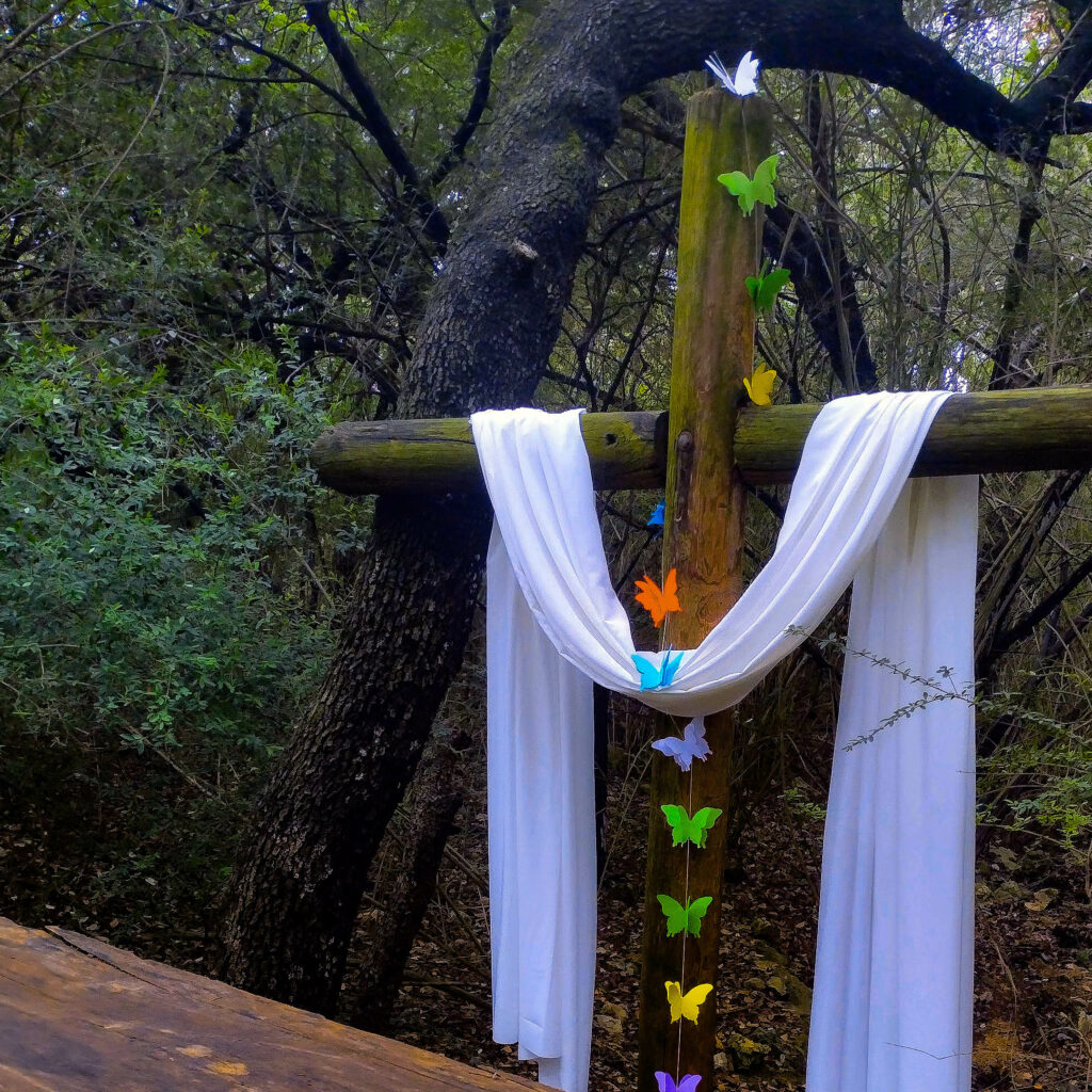 outdoor cross with butterflies and white veil